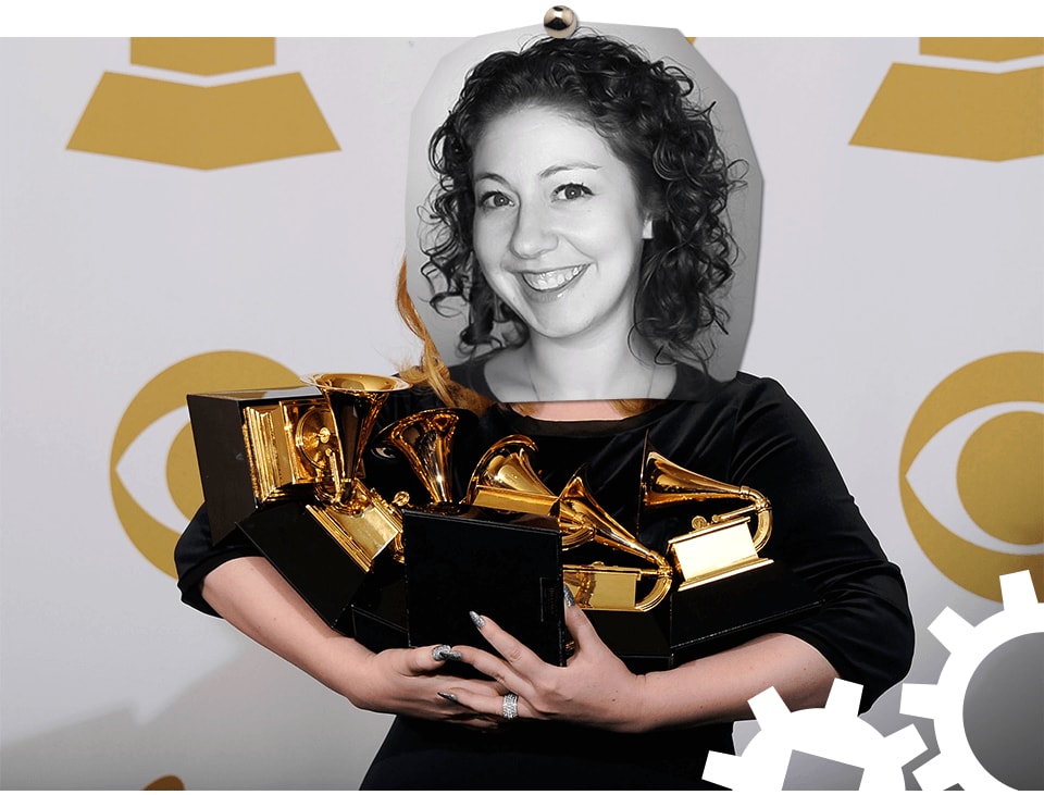 Penney's face photoshopped onto someone holding lots of Grammy awards.