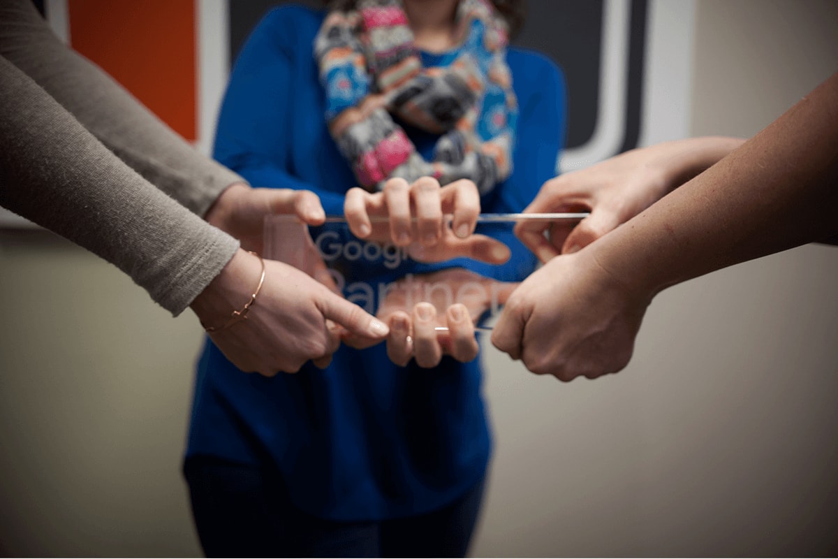 Google certified Ramsey MediaWorks employees grabbing tightly the Google Premier Partner desk plaque.