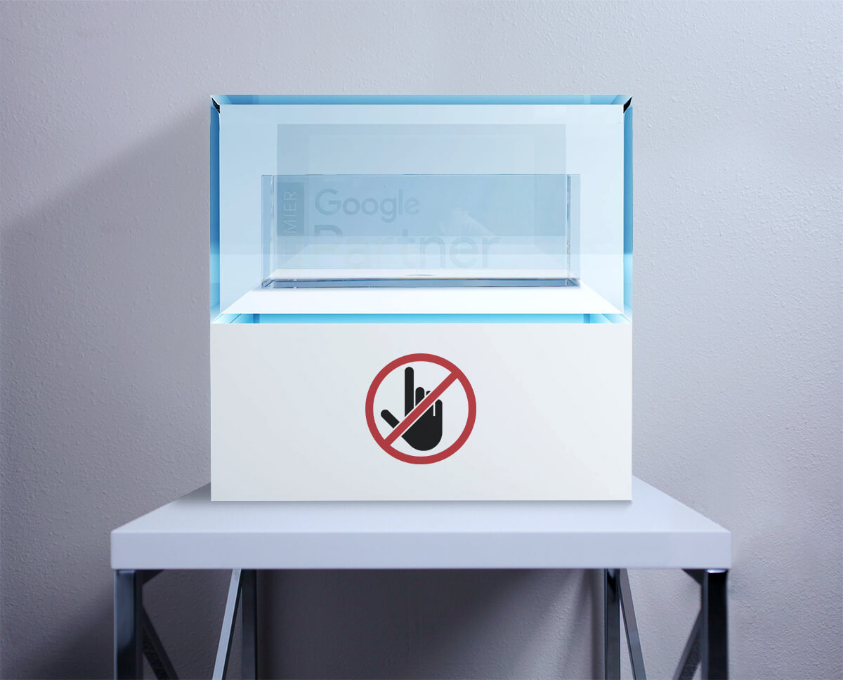 A display case with a no-touch sign protecting the Google Premier Partner desk plaque.