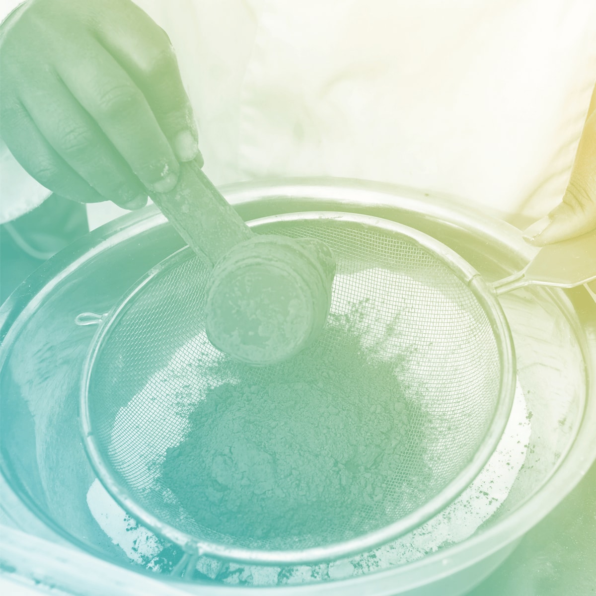 A cook measuring ingredients out of a sifter.