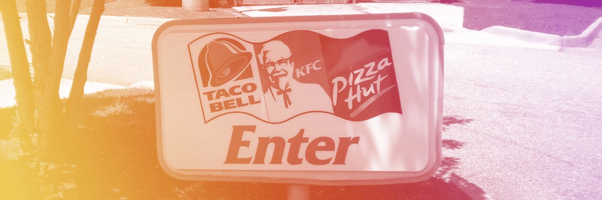Taco Bell, KFC, and Pizza Hut logos on one enter sign.
